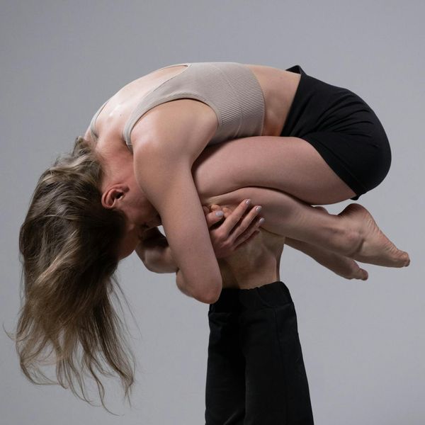 Woman holding a challenging balancing yoga pose demonstrating strength and focus.